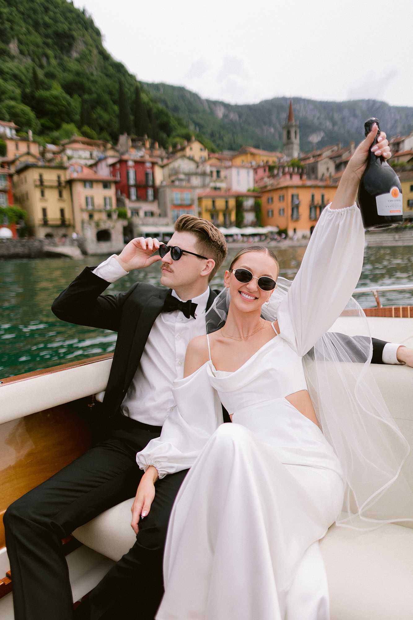 Editorial wedding photo of a couple celebrating on a boat in Lake Como, captured by a destination wedding photographer