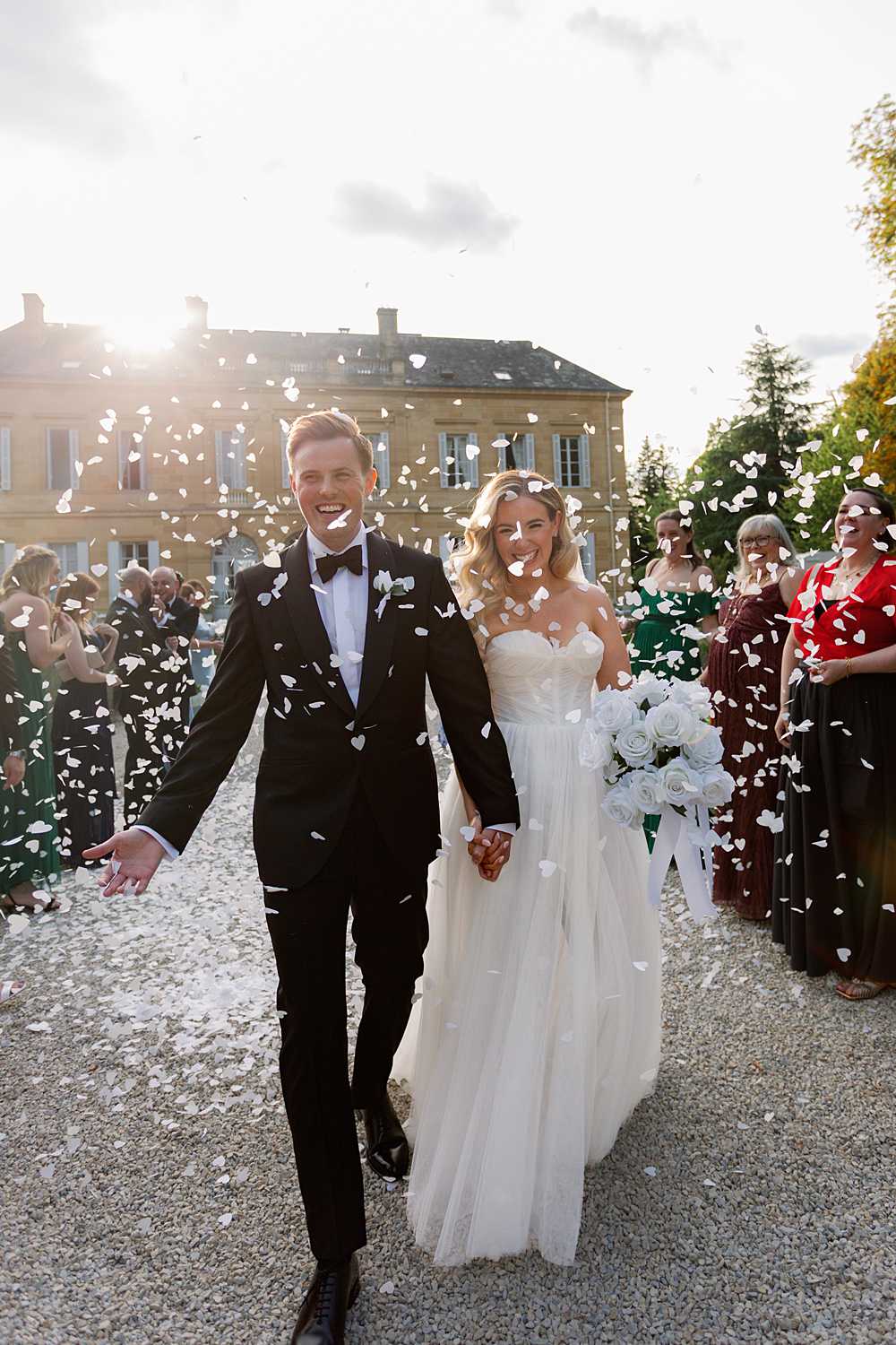 confetti exit at chateau la durantie wedding in dordogne with bride and groom celebrating outdoors