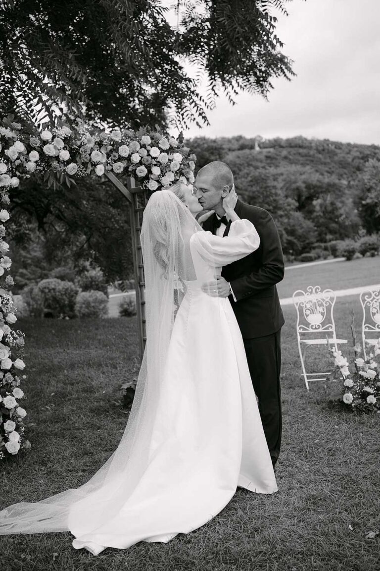 Bride and groom sharing a kiss during an outdoor ceremony at Château de Saint Martory in southwest France