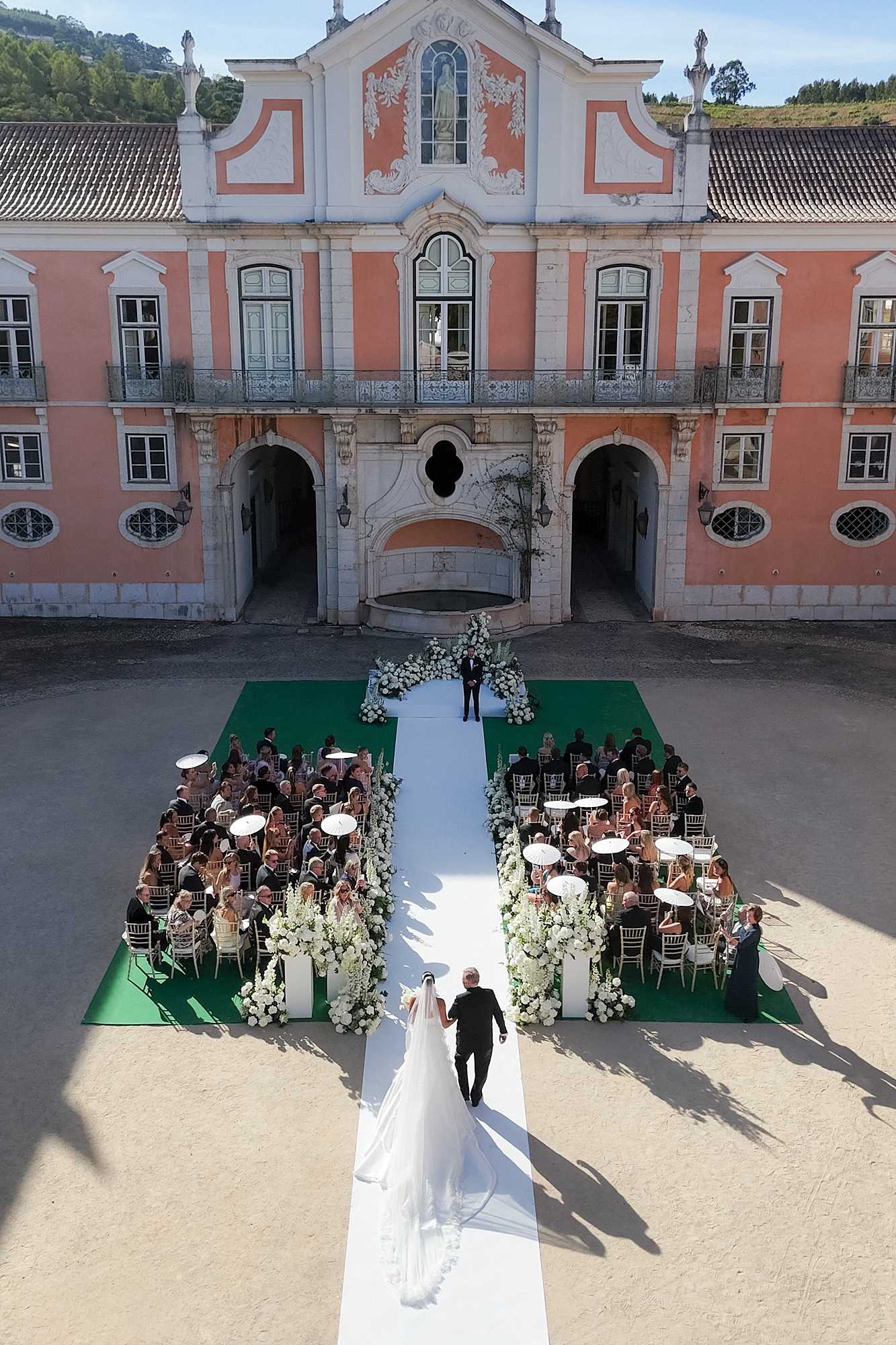 Bride walking to up the aisle during her ceremony at Palacio do Correio-Mor Wedding in Lisbon. Photographed from a high on a drone.